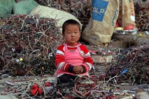 Child surrounded by toxic electronic waste and scraps Child surrounded by toxic electronic waste and scraps